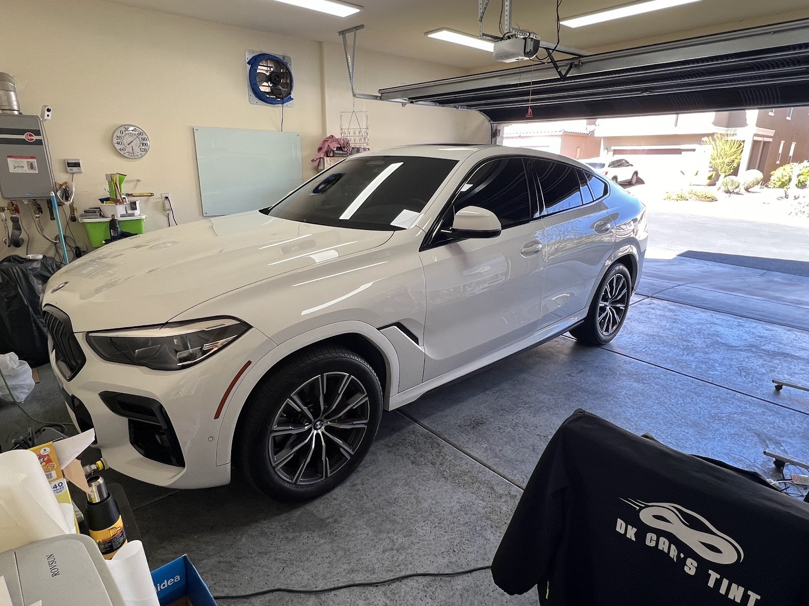 White BMW X6 with freshly tinted windows inside the tinting garage