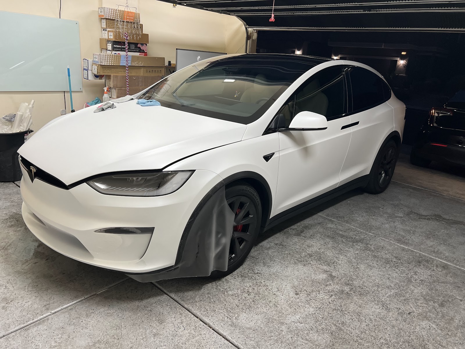 White Tesla Model X with tinted windows inside the tint shop